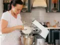 Une femme verse de la farine dans un robot pâtissier. Quel fouet pour pétrir !
