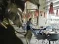 Serveuse préparant les tables dans un restaurant chic. Le 11 novembre est férié, mais ce restaurant est ouvert pour vous accueillir.