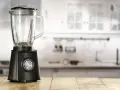 Blender noir sur table en bois. Peut-on hacher de la viande avec un blender ? Cet appareil est prêt à relever le défi.