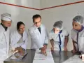 Cinq personnes en tenue de cuisine étudient des documents. Le chef montre un point précis, peut-être pour un double emploi ou une nouvelle procédure.