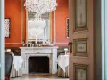 Salle à manger élégante avec cheminée, lustres et tables dressées. Un décor parfait pour savoir comment être référencé dans le Petit Futé.