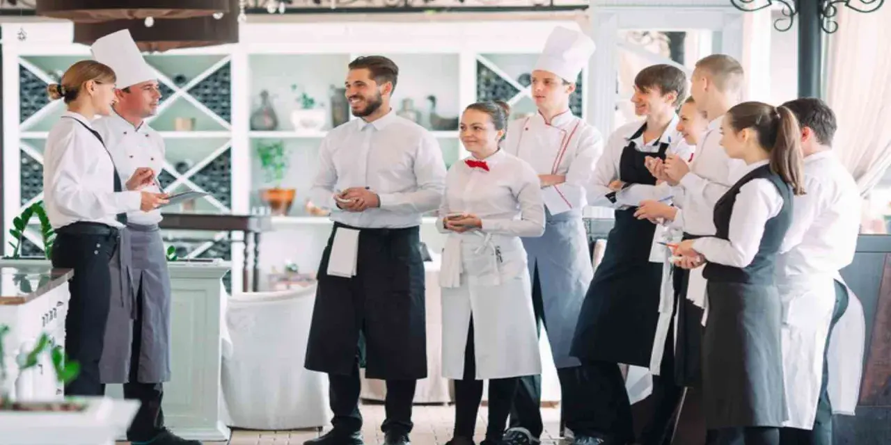 L'équipe d'un restaurant en uniforme, discutant de la gestion du personnel.