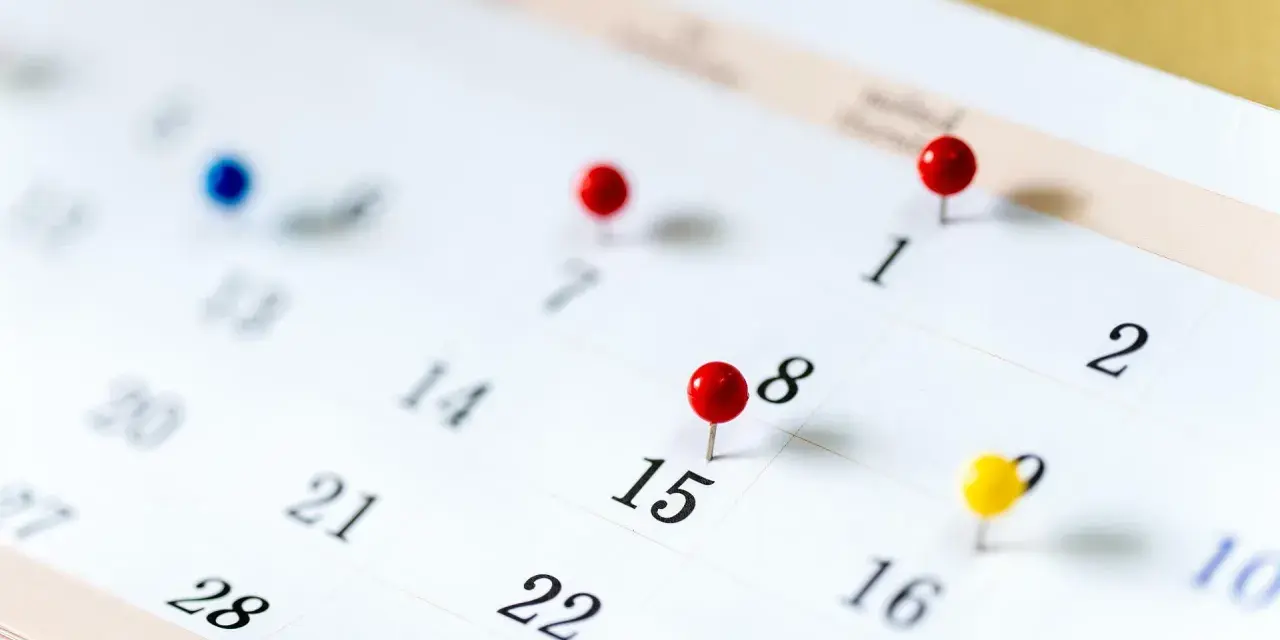 Un calendrier avec des punaises marque des dates importantes. Il est difficile de déterminer quels sont les 6 jours fériés garantis HCR sans plus de contexte.