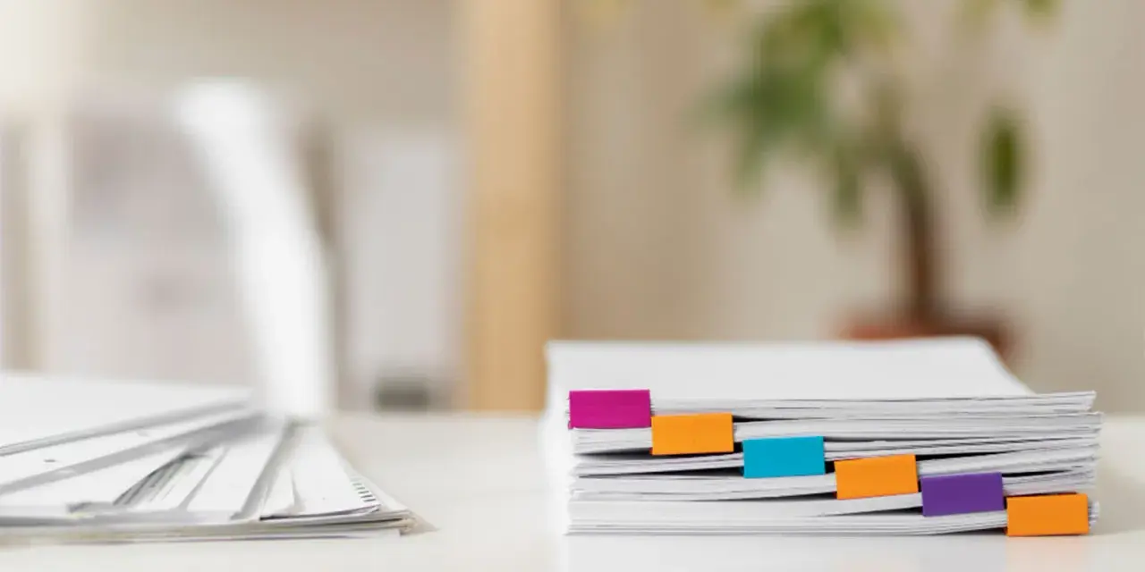 Pile de documents RH organisée avec des onglets colorés.