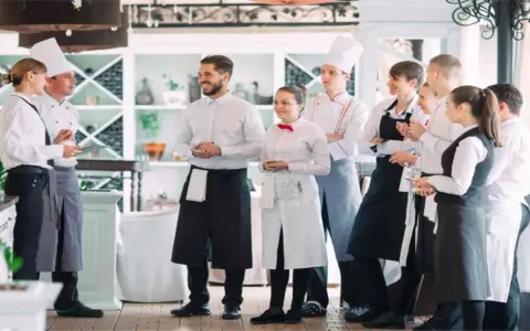 L'équipe d'un restaurant en uniforme, discutant de la gestion du personnel.