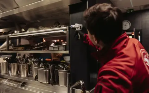 Un technicien en cuisine applique un produit. Une fermeture exceptionnelle pour une hygiène parfaite.