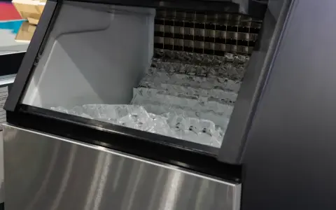 Machine à glaçons professionnelle remplie de glaçons. Un problème de production de glace est suspecté.