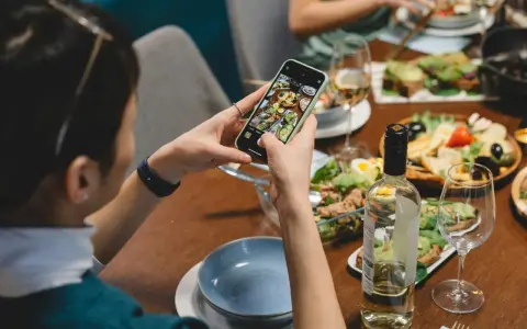 Une food influencer capture un repas coloré avec son téléphone, prête à partager ses découvertes culinaires.