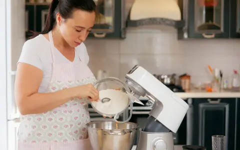 Une femme verse de la farine dans un robot pâtissier. Quel fouet pour pétrir !