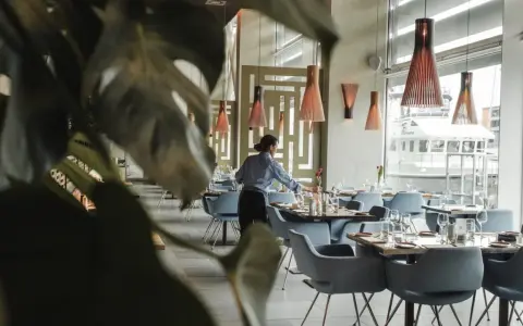 Serveuse préparant les tables dans un restaurant chic. Le 11 novembre est férié, mais ce restaurant est ouvert pour vous accueillir.