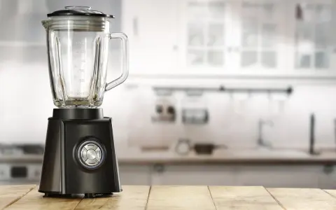 Blender noir sur table en bois. Peut-on hacher de la viande avec un blender ? Cet appareil est prêt à relever le défi.