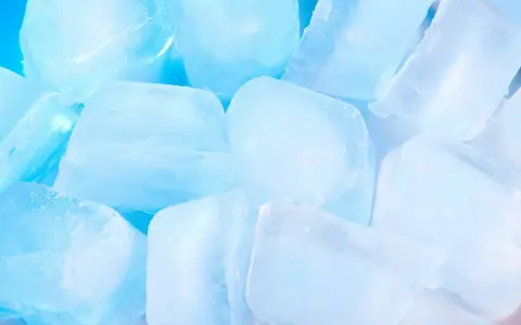 Gros plan sur des glaçons translucides et bleutés, parfaits pour savoir comment faire des glaçons rapidement et rafraîchir vos boissons.
