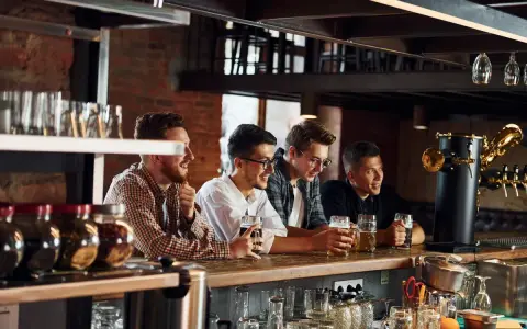 Quatre amis discutent et rient au bar, bières à la main. Le bruit de leur joie ne dérange personne, mais jusqu'à quelle heure un bar peut faire du bruit ?