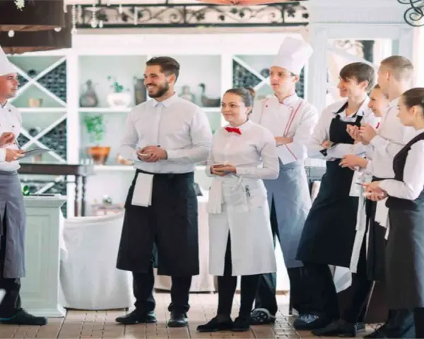 L'équipe d'un restaurant en uniforme, discutant de la gestion du personnel.