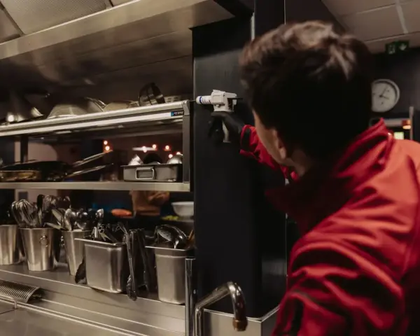 Un technicien en cuisine applique un produit. Une fermeture exceptionnelle pour une hygiène parfaite.