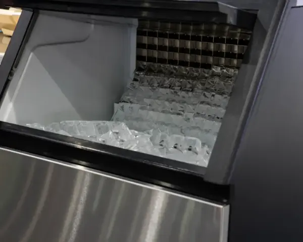 Machine à glaçons professionnelle remplie de glaçons. Un problème de production de glace est suspecté.
