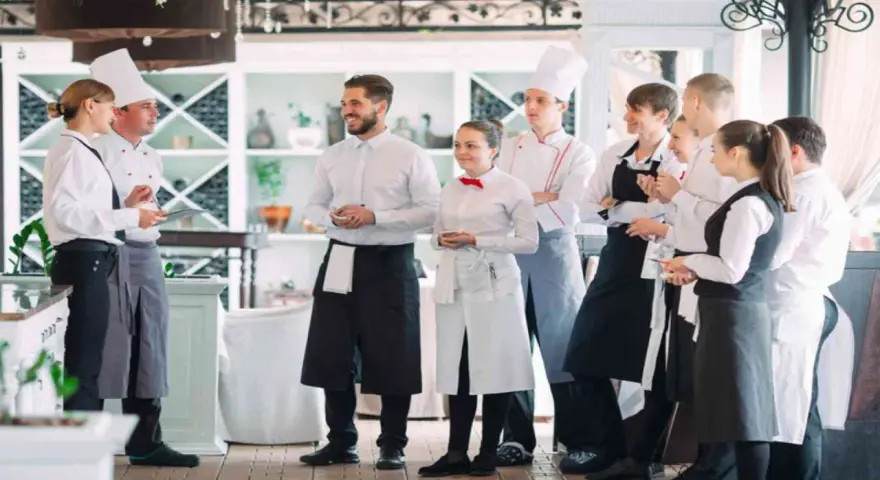 L'équipe d'un restaurant en uniforme, discutant de la gestion du personnel.