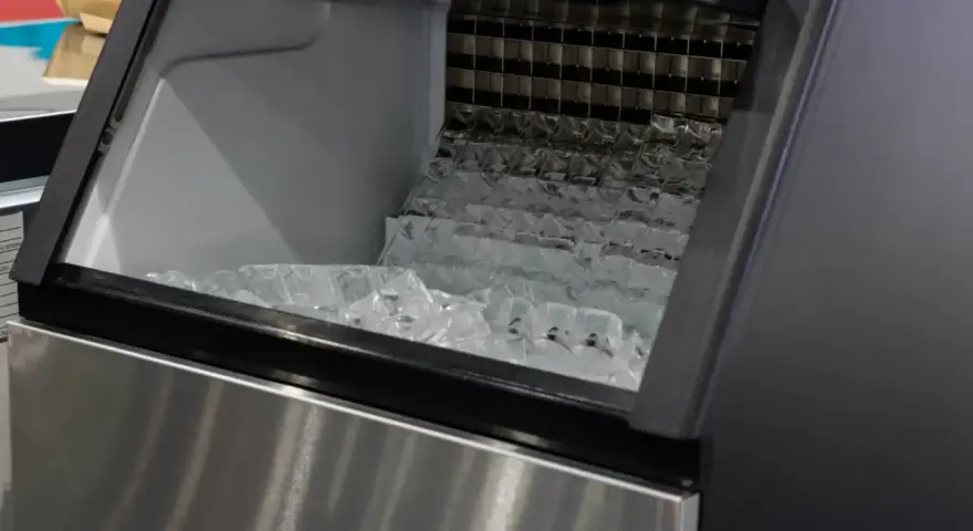 Machine à glaçons professionnelle remplie de glaçons. Un problème de production de glace est suspecté.