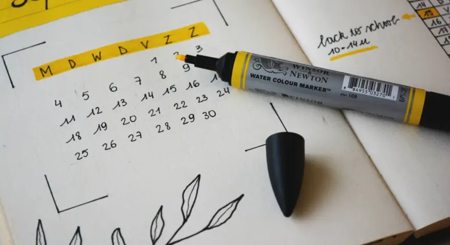 Un calendrier des marronniers pour septembre, avec un marqueur jaune et des décorations florales.