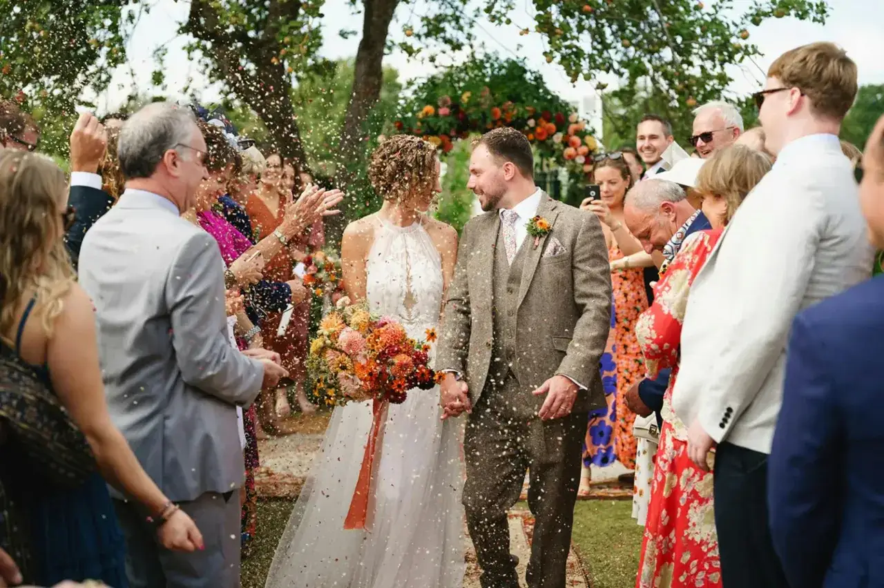 Mariés sous une pluie de confettis, entourés de leurs proches. Un moment de joie pour ce congé pour mariage.