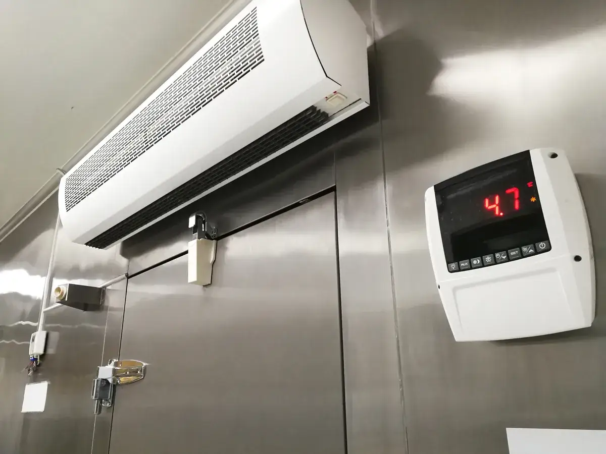 Chambre froide avec unité de climatisation et thermomètre affichant 4.7°C.