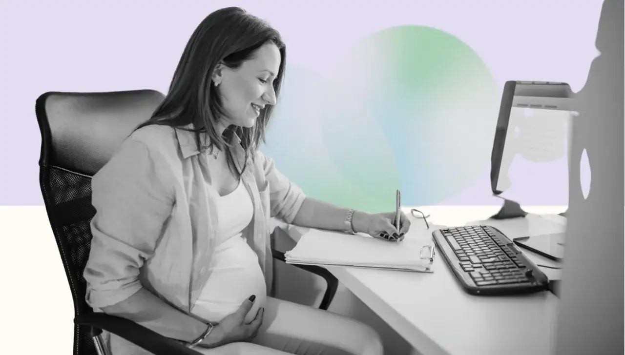 Femme enceinte souriante travaillant à son bureau, préparant son congé maternité.
