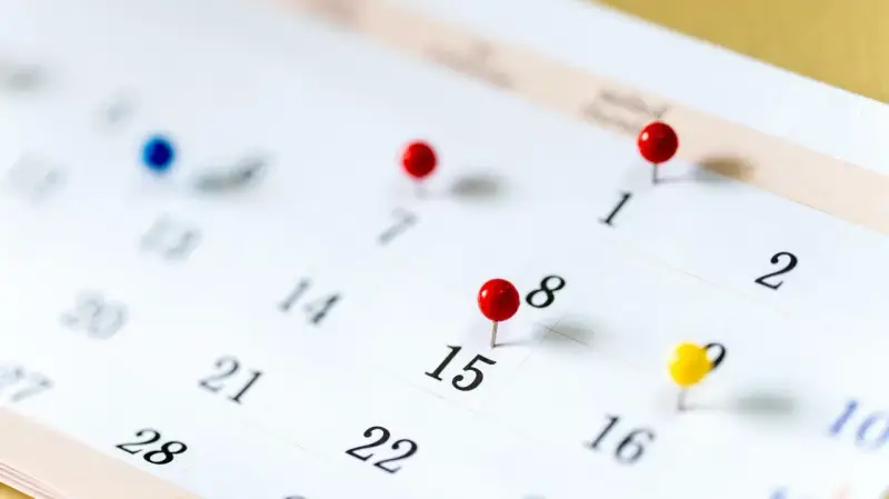 Un calendrier avec des punaises marque des dates importantes. Il est difficile de déterminer quels sont les 6 jours fériés garantis HCR sans plus de contexte.